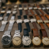 Collection de montres vintage exposées sur un fond en bois élégant, mettant en valeur des pièces de luxe anciennes.